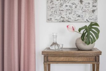 Roze gordijn naast tafel met decoratie