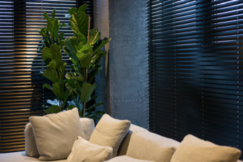 Zwarte jaloezieën bij bank